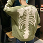 Pull vert avec motif de squelette